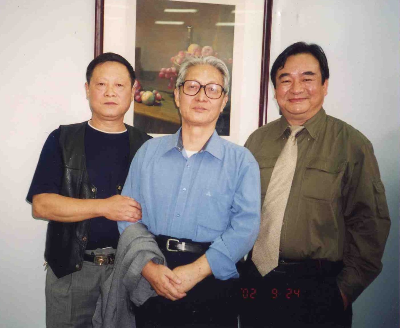 Yim Mau-Kun and others with his Changde art teacher Zhou Xinzhong in front of a framed still-life painting, 2002