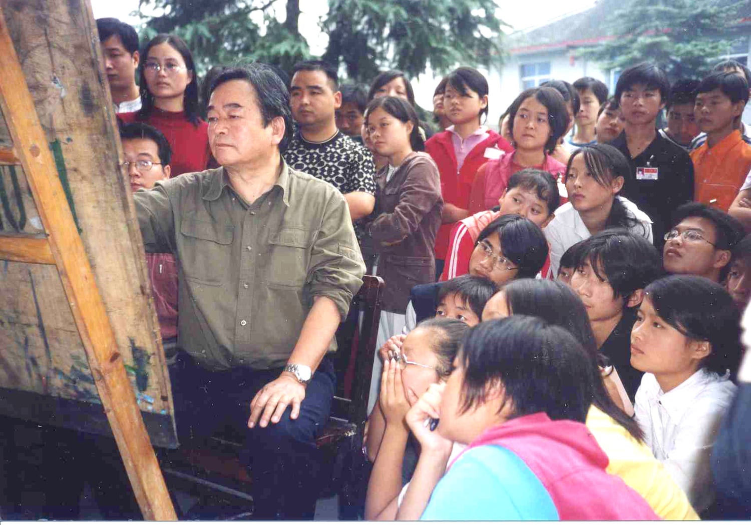 Yim Mau-Kun at an easel giving a drawing demonstration, surrounded by students watching intently, Taoyuan 1998