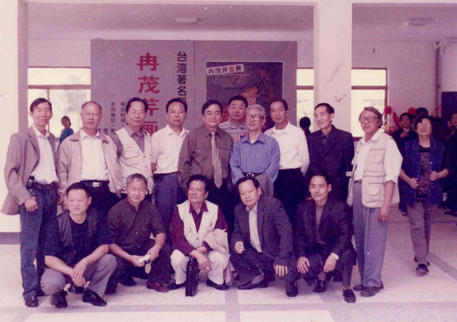 冉茂芹在常德個展開幕式上與一群當地畫家合影，身後橫幅寫著「冉茂芹」